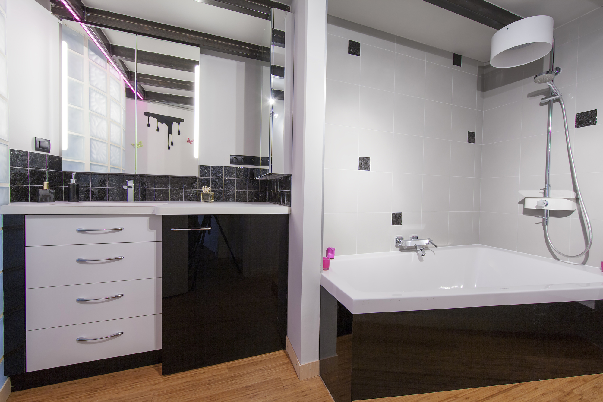 A bathroom with black and white features and a bathtub.