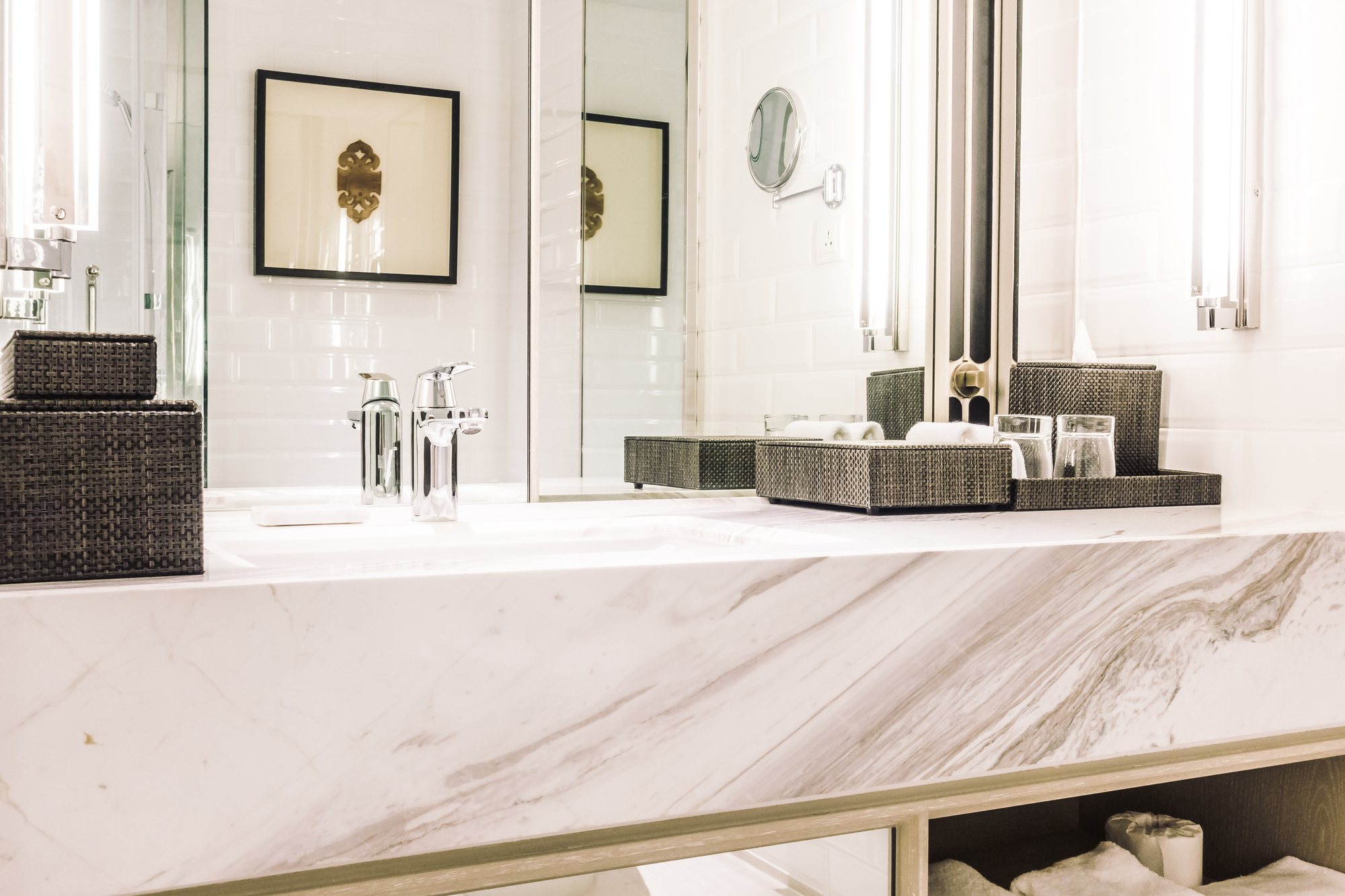 A marble vanity countertop with a sink and mirrors.