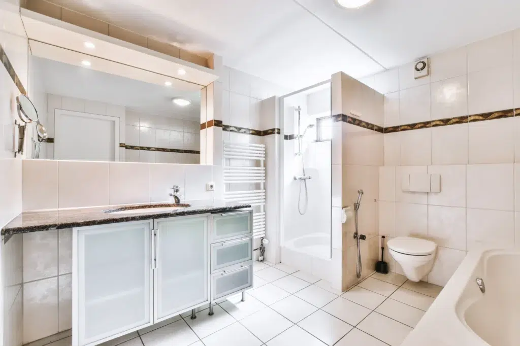 A recently renovated bathroom with fresh white tile and a new floor