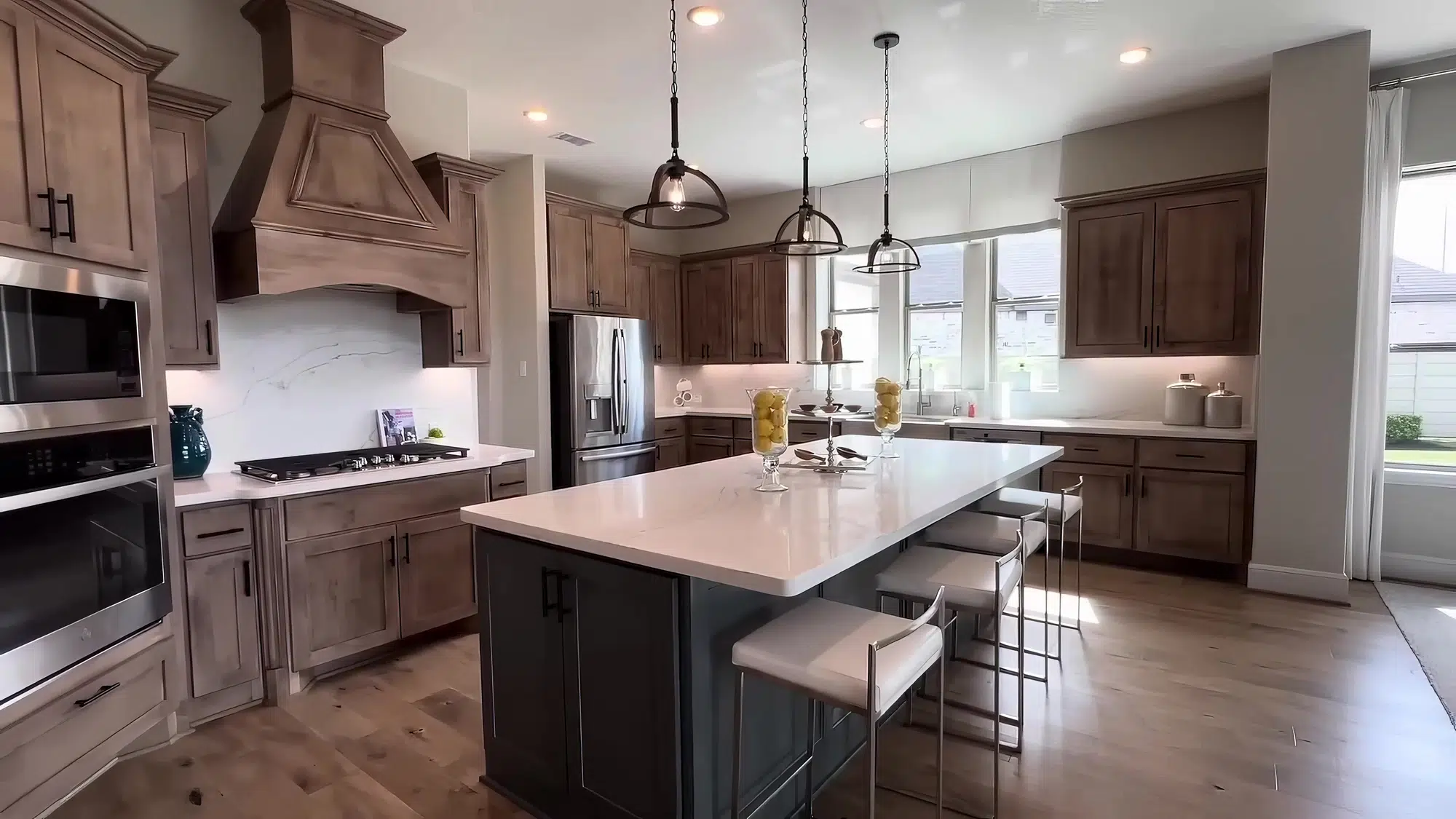A modern kitchen with wooden drawers, cabinets, and an island with a marble countertop.