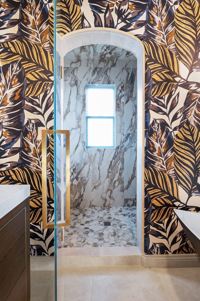Luxurious bathroom shower in Huntington Beach, CA, featuring a marble-look acrylic shower with hexagonal floor tiles
