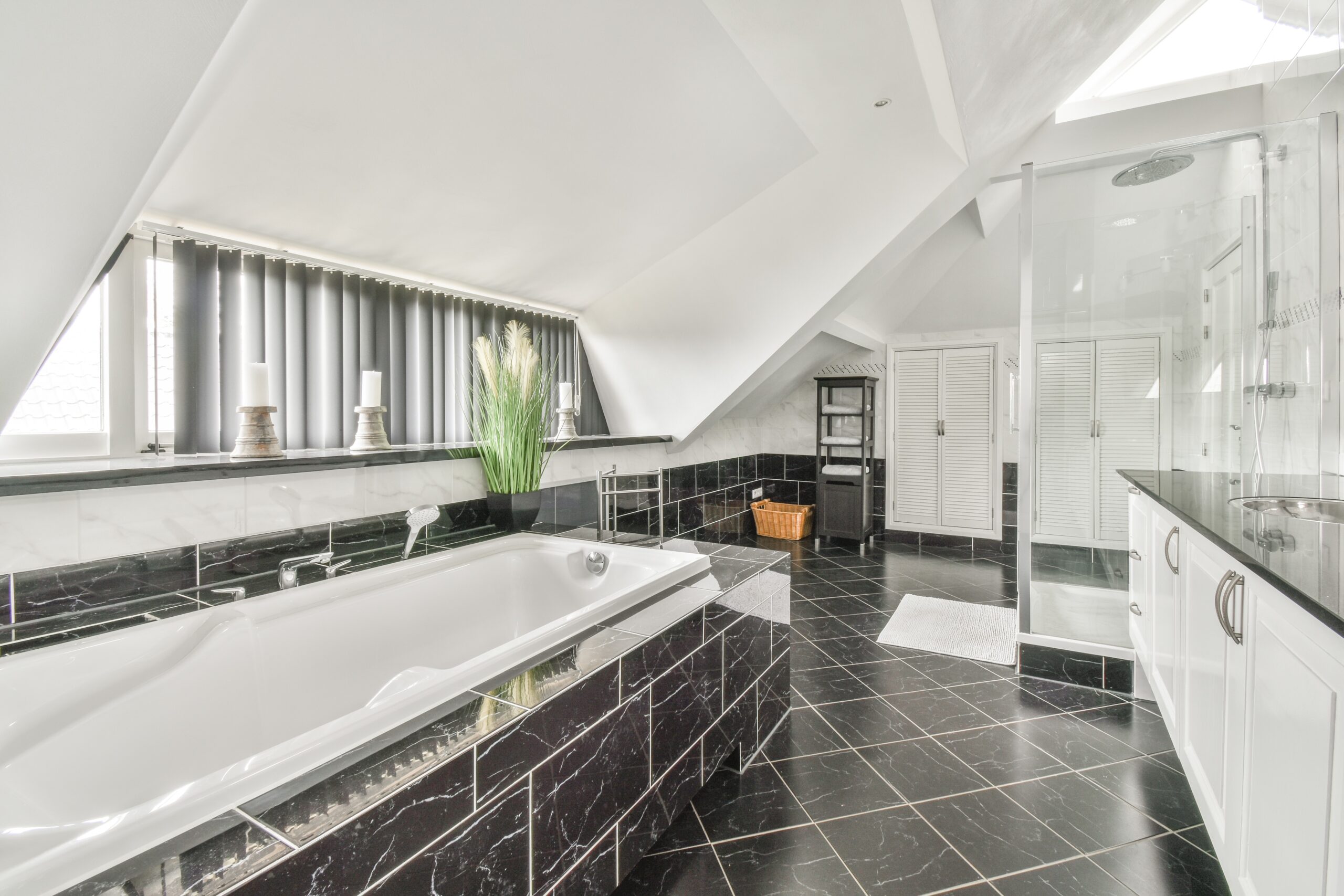 Bright, modern kitchen remodel featuring black lower cabinets, warm wood countertops, a large island with sink, tile backsplash, and ample natural light.
