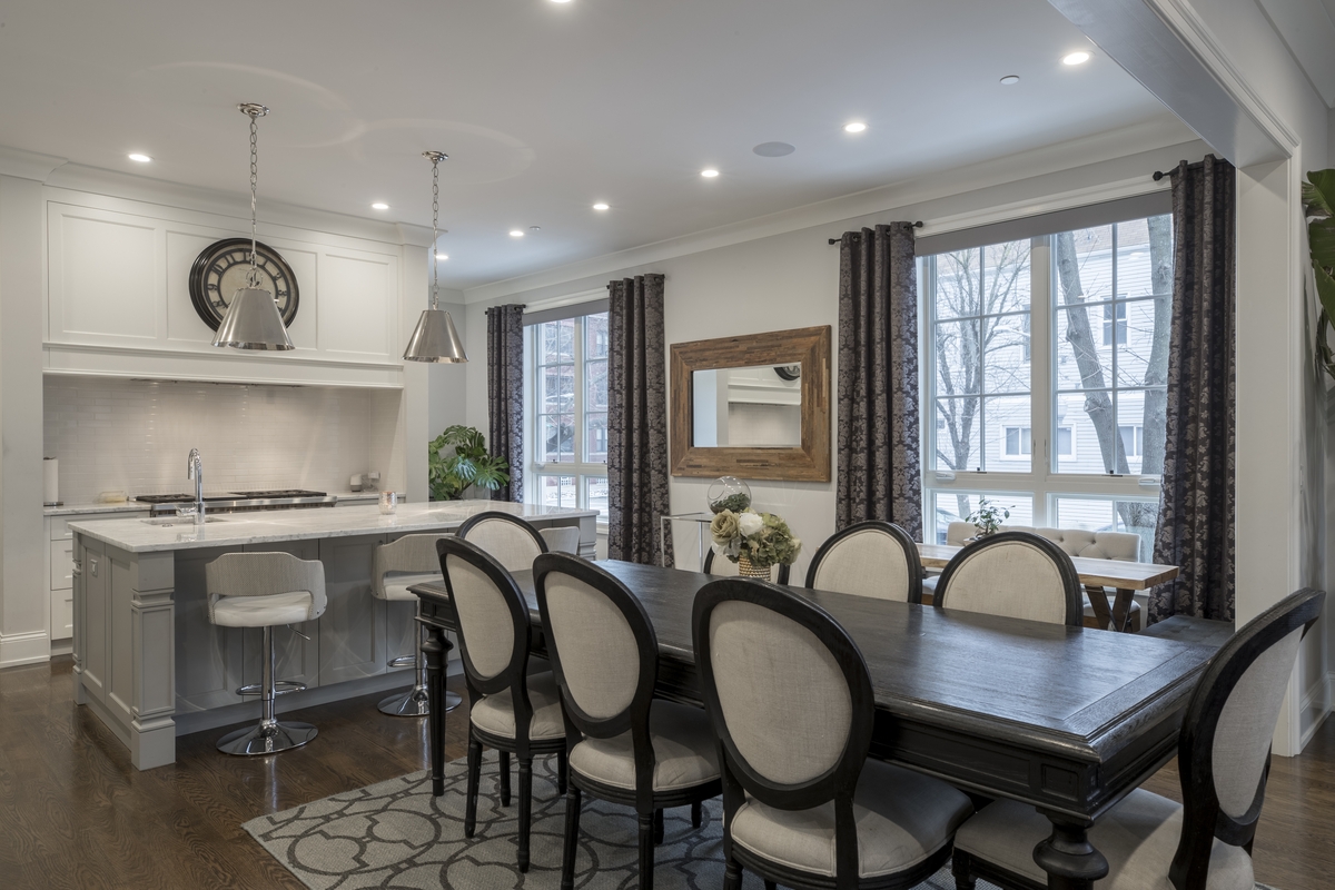 Beautiful Kitchen Remodeling | San Pedro, CA | EGM Construction An elegant open-concept dining area and kitchen feature a large marble-topped island, stylish pendant lighting, and classic wood furniture following a professional kitchen remodeling project.