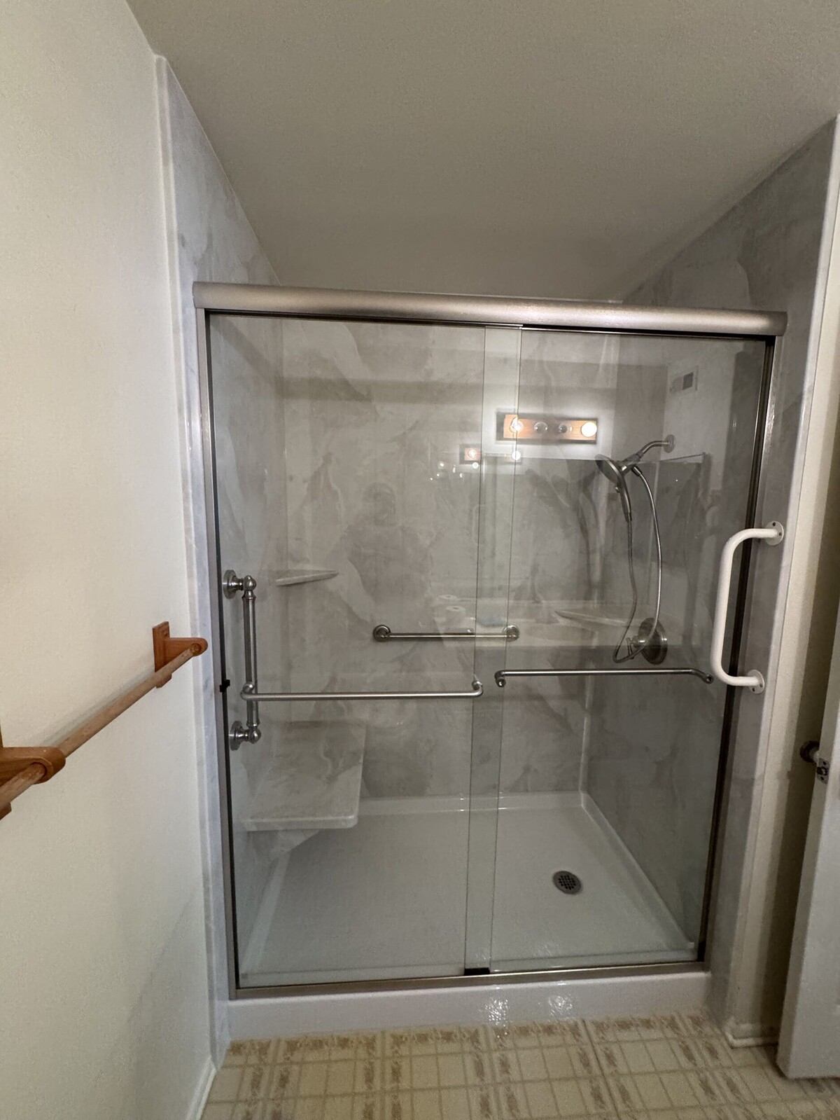 Professional Bathroom Remodeling Services | San Pedro, CA | EGM Construction A modern, glass-enclosed walk-in shower featuring a built-in seat and safety grab bars showcases the accessible updates from a professional bathroom remodeling project.